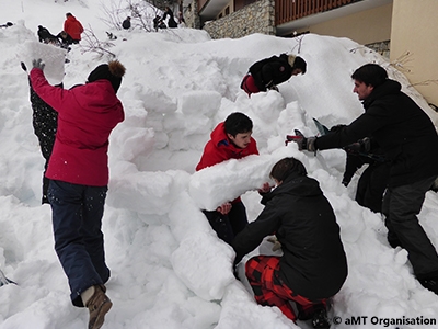 adultes qui construisent un igloo avec de la neige