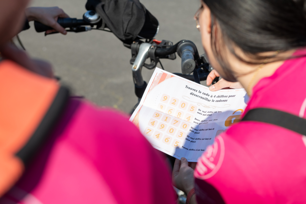 Participants consultant une énigme à résoudre lors d’un rallye à vélo organisé dans le cadre d’un team building.