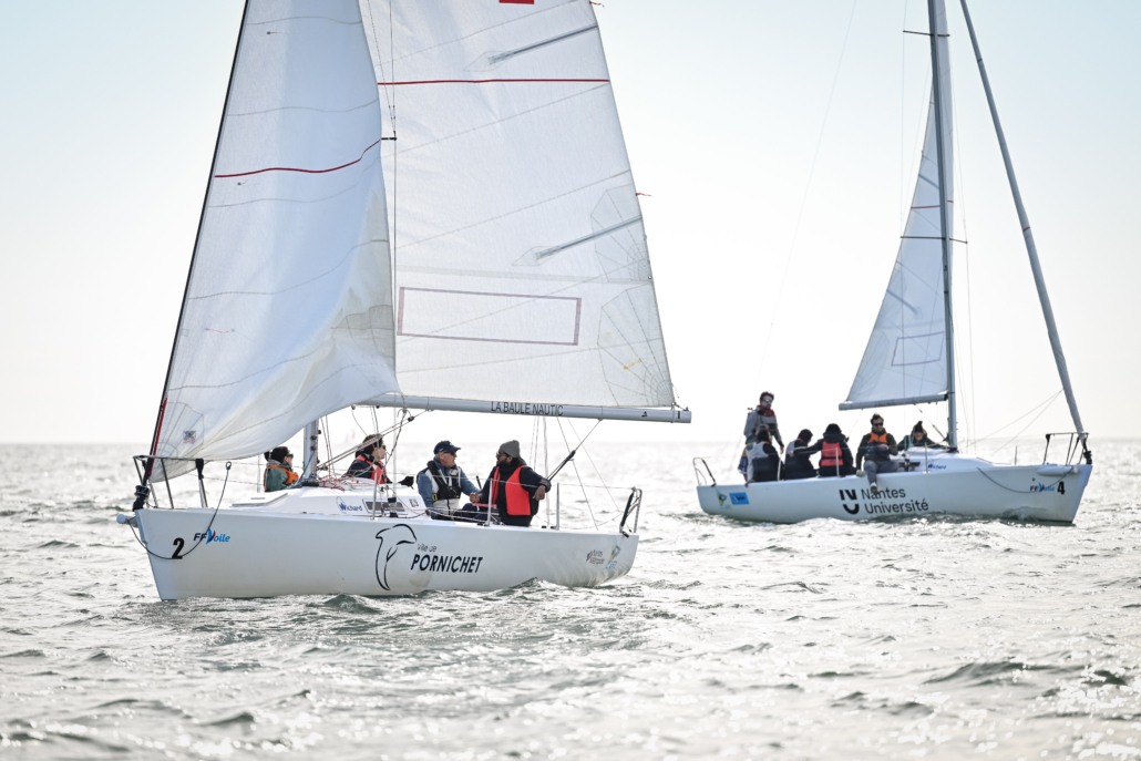 Plusieurs voiliers en course sur le plan d’eau dans le cadre d’un challenge nautique inter-équipes.
