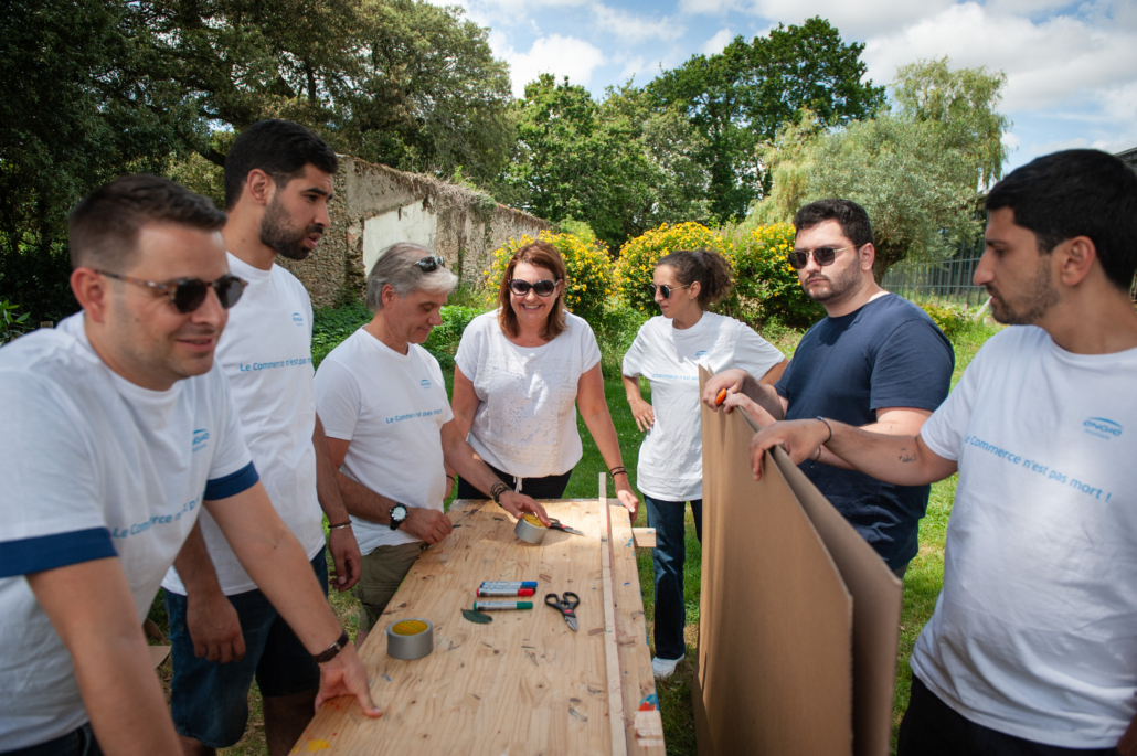 Collaborateurs préparant une structure en carton lors d’une activité de construction collective.