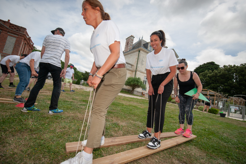 Participants avançant sur des skis géants nécessitant coordination et synchronisation.