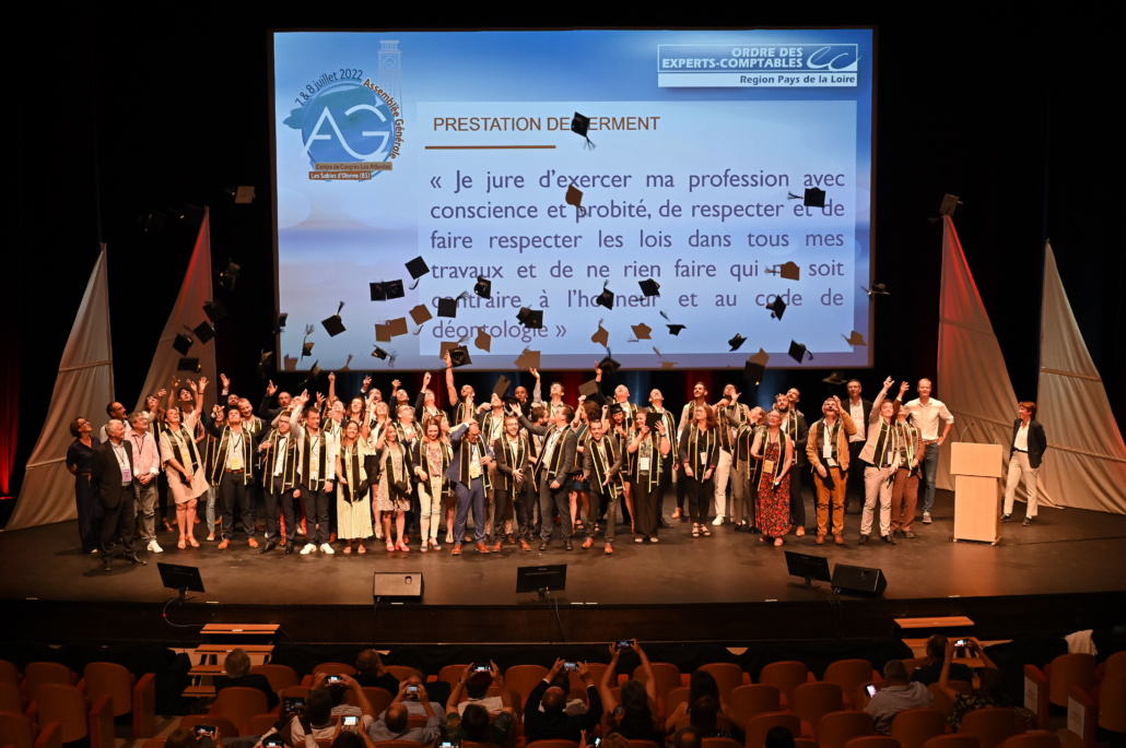 Nouveaux diplômés réunis sur scène après leur prestation de serment lors d'une cérémonie professionnelle