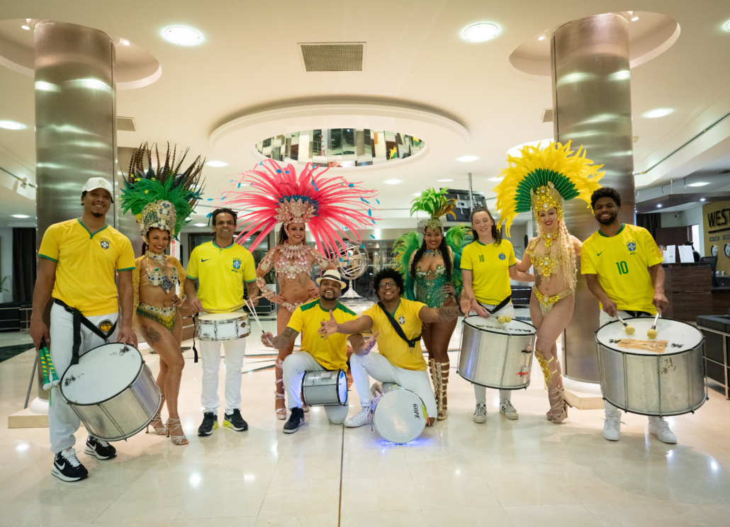 Artistes brésiliens, danseuses de carnaval et batucada posent ensemble avant une animation de soirée d’entreprise sur le thème du Brésil.