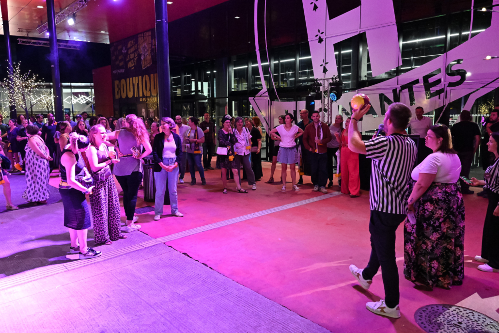 Participants réunis autour d’un animateur lors d’un jeu collectif en soirée.